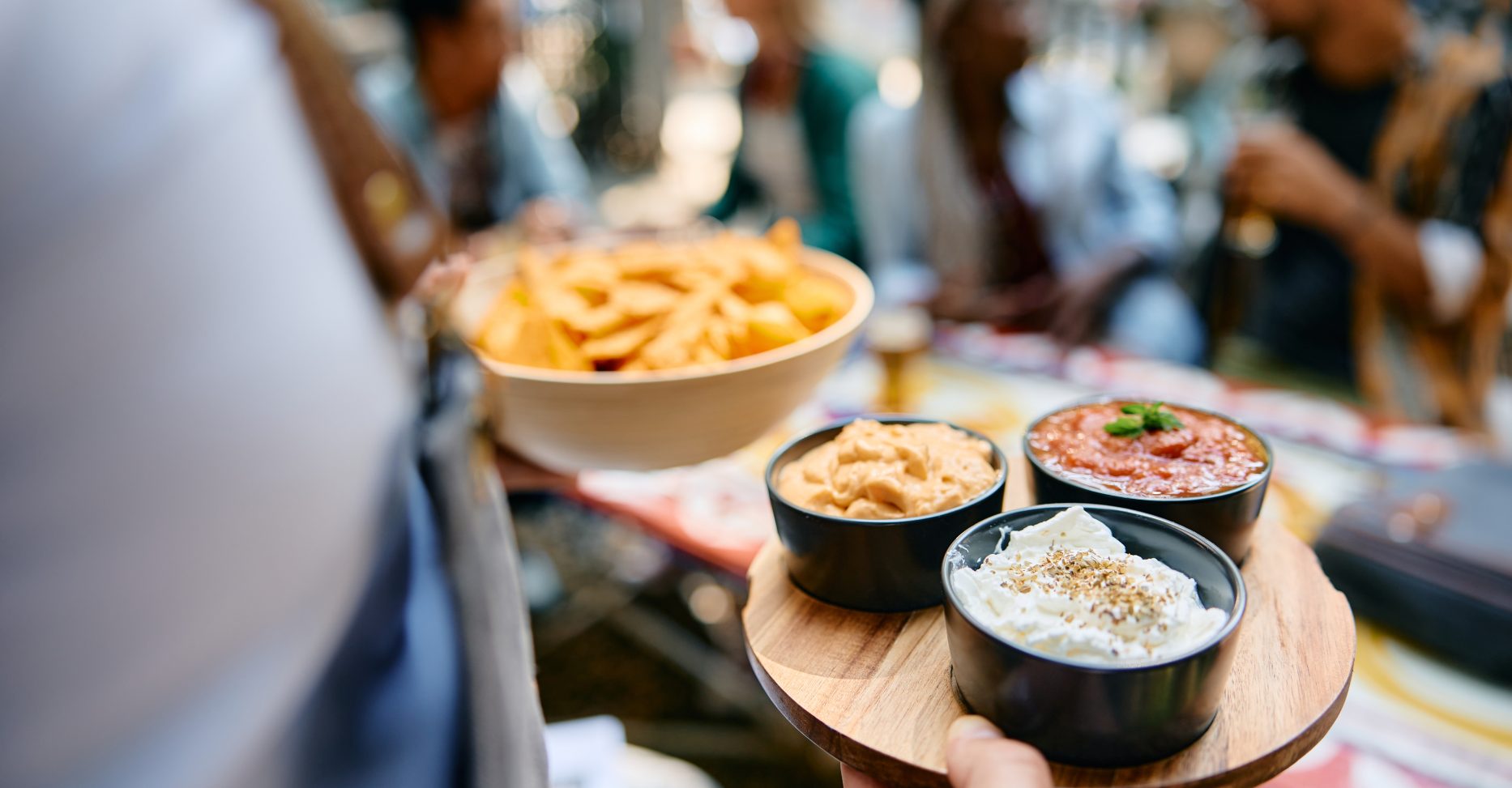 Close up of waiter serving food while working in a restaurant.