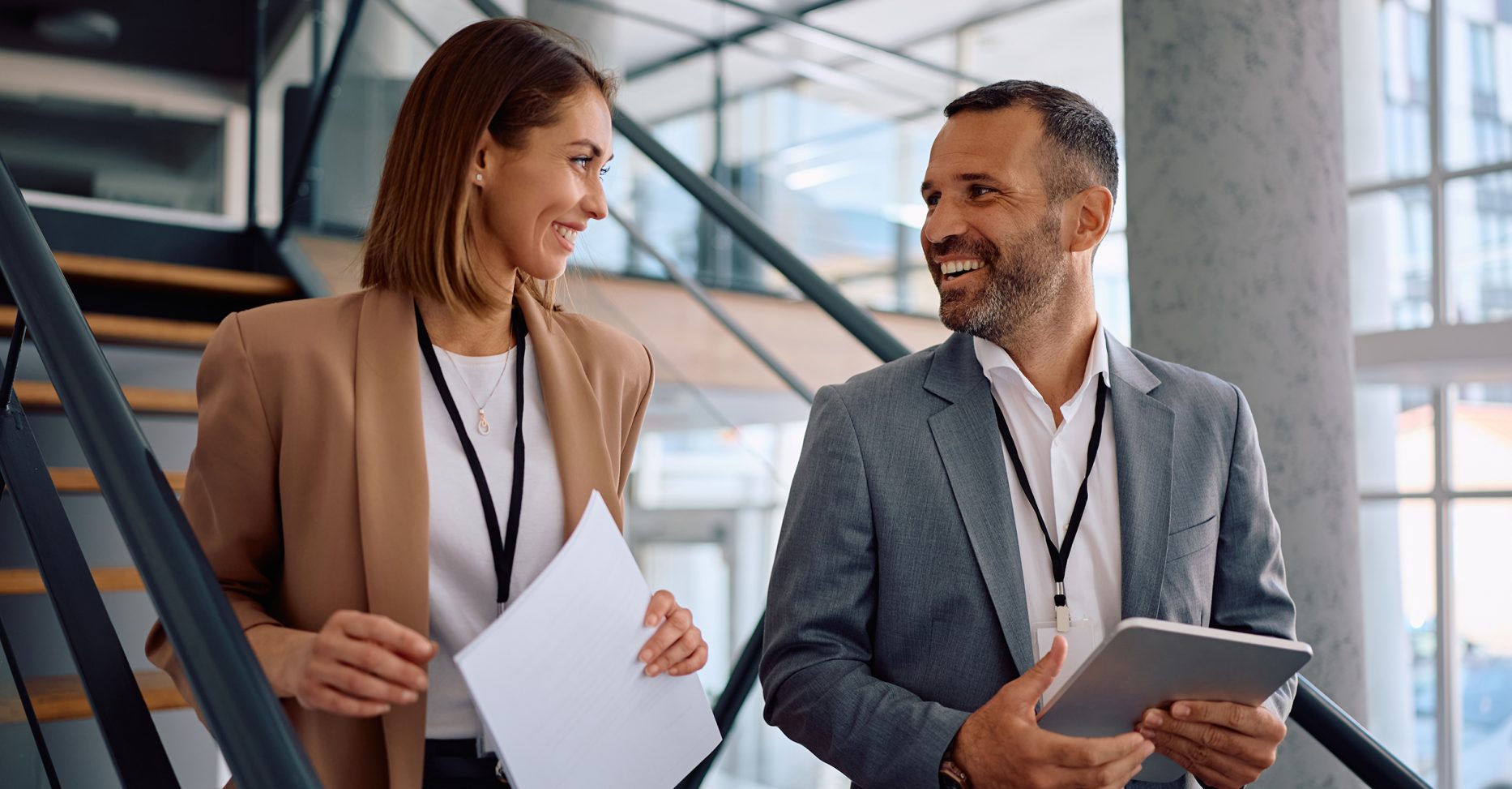 Happy,Businessman,Talking,To,His,Female,Colleague,While,Working,In