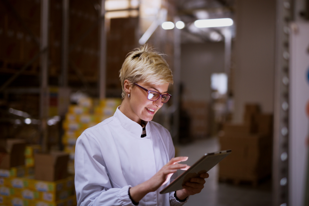 Young,Female,Manager,Is,Using,Tablet,In,Storage,Room,Of