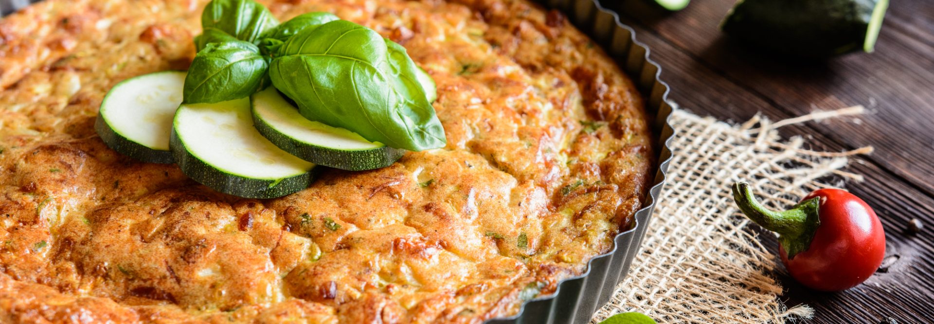 Zucchini pie with bacon, cheese, onion, parsley and basil