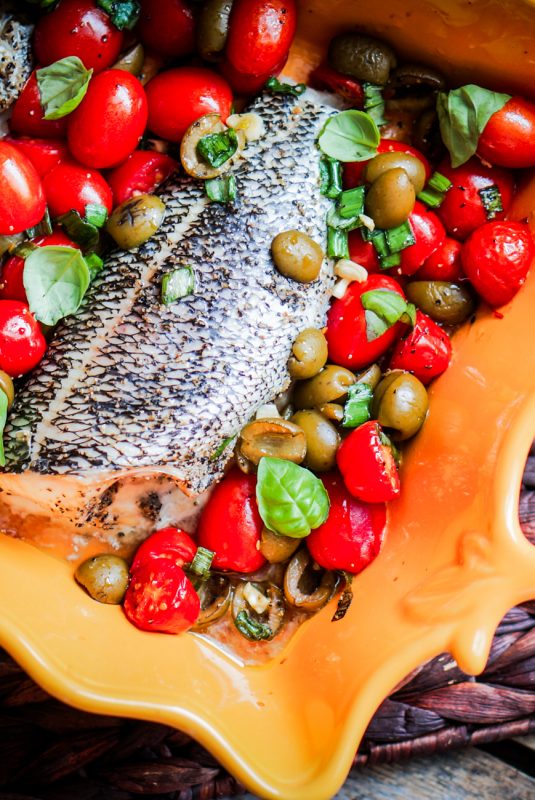 Baked Seabass With Tomatoes And Basil On Rustic Wooden Background