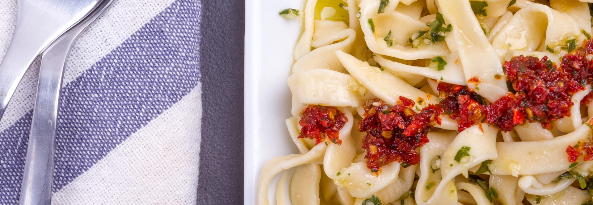 Pasta tagliatelle ready to eat with tomato sauce and basil