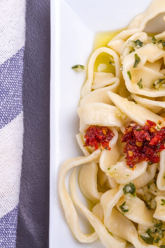 Pasta tagliatelle ready to eat with tomato sauce and basil