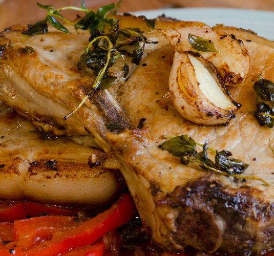 Grilled pork chops with red peppers and herbs