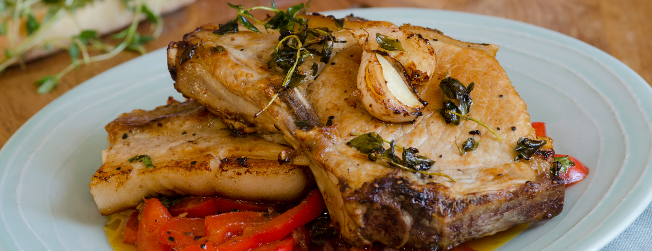 Grilled pork chops with red peppers and herbs
