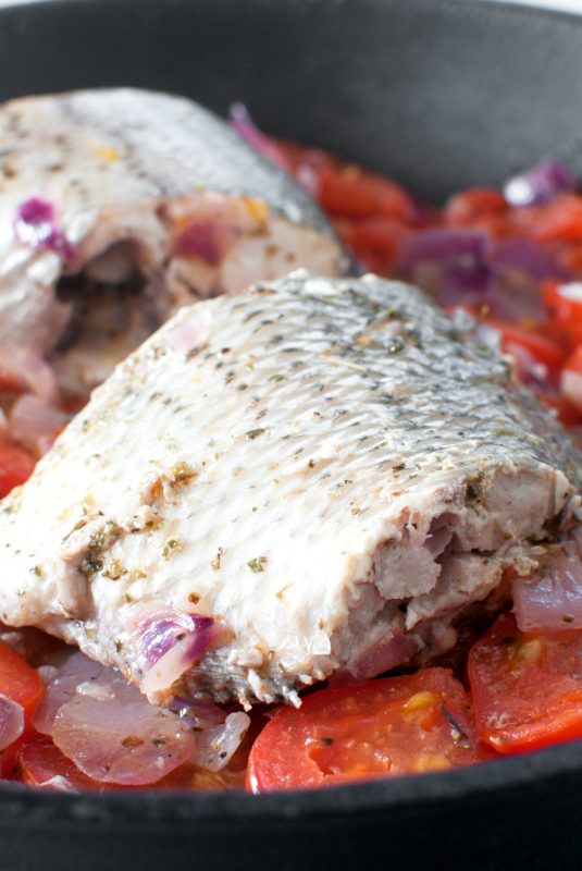 Sauteed bass fish pieces with tomatoes and onion