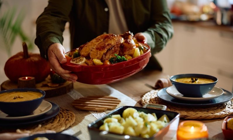 Close,Up,Of,Man,Serving,Roast,Turkey,For,Thanksgiving,Dinner