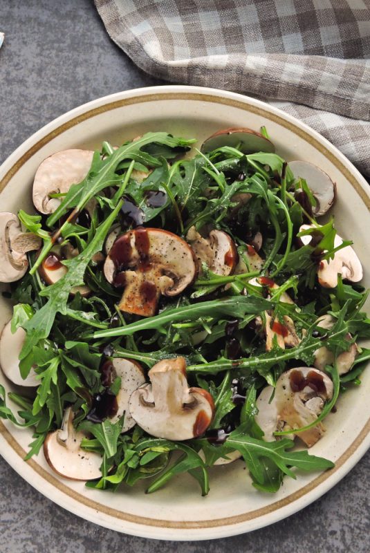 Healthy salad with arugula and raw champignons.